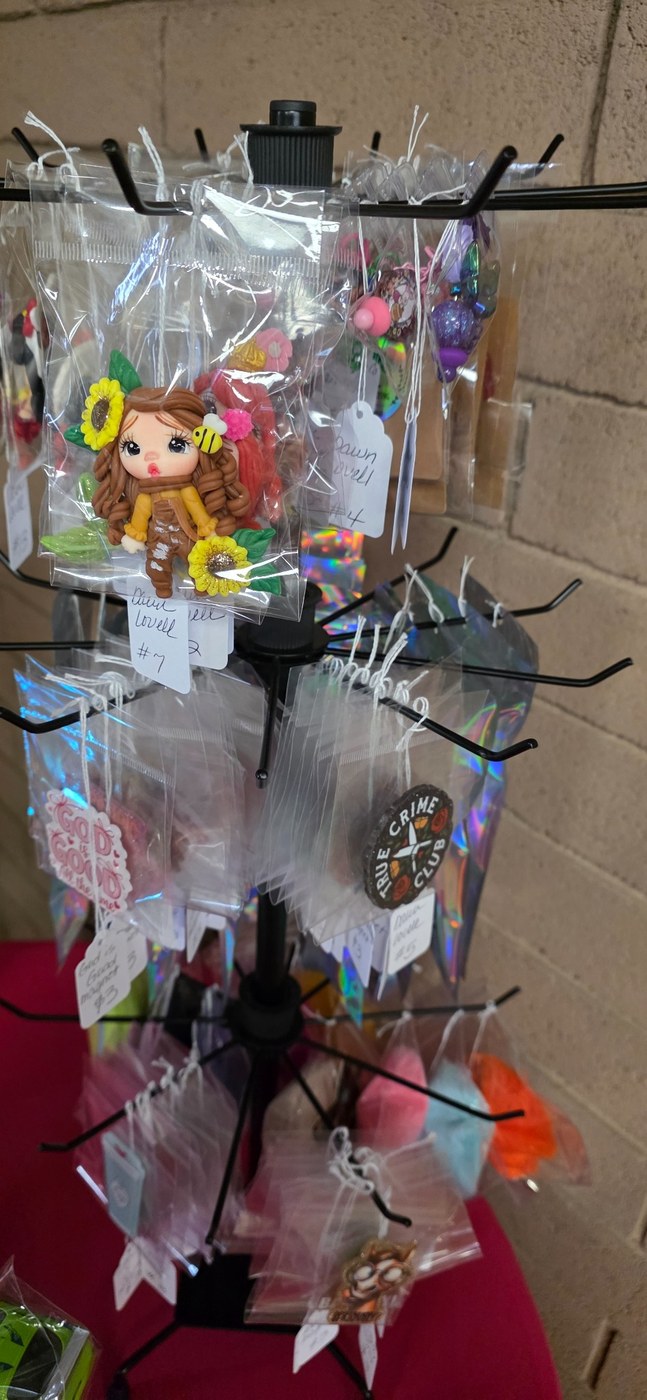 A closer view of Dawn Lovell's sunflower character and colorful accessories on a hanging display