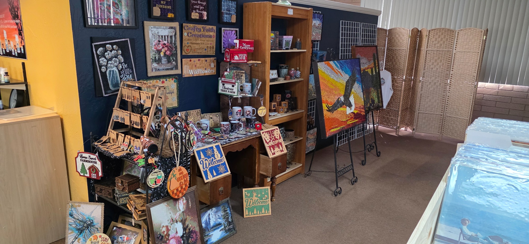 Colorful artwork and handmade goods displayed inside Cottonwood Makers Mart